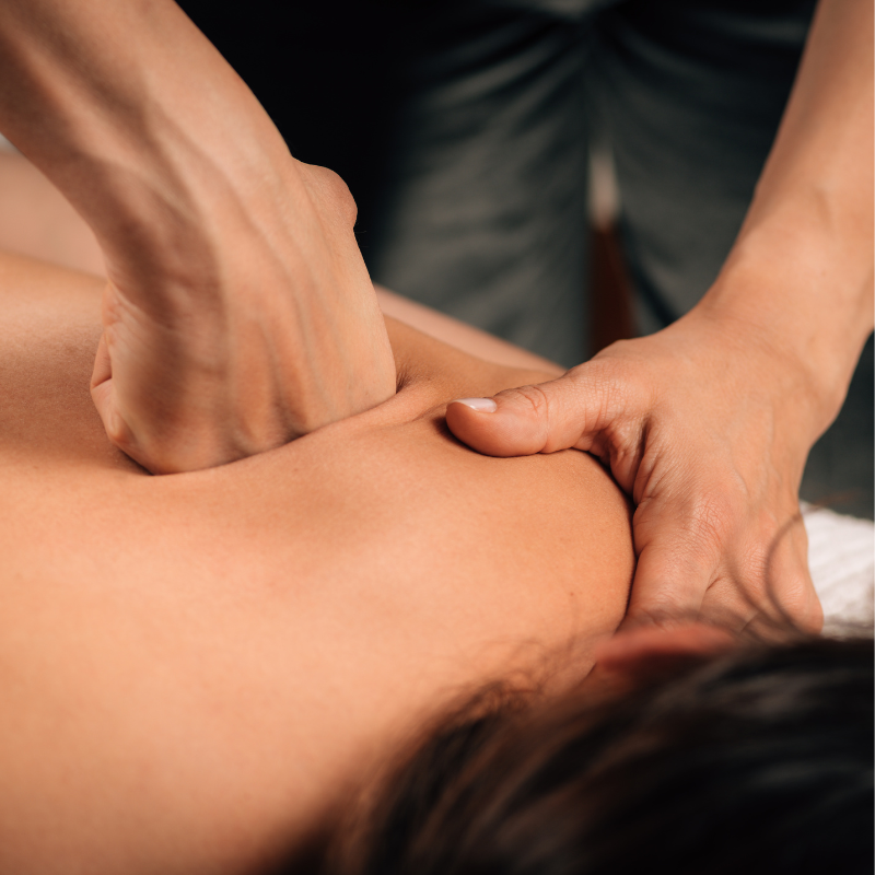 A close-up photo of an acupuncture practitioner's hand holding a needle next to a patient's hand.