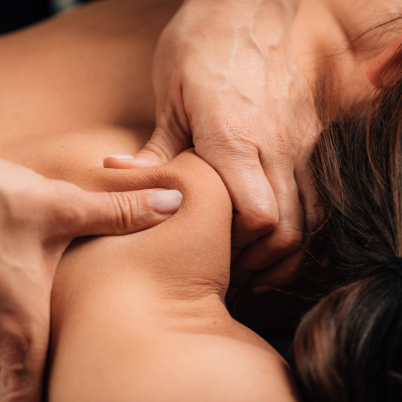 A close-up photo of an acupuncture practitioner's hand holding a needle next to a patient's hand.
